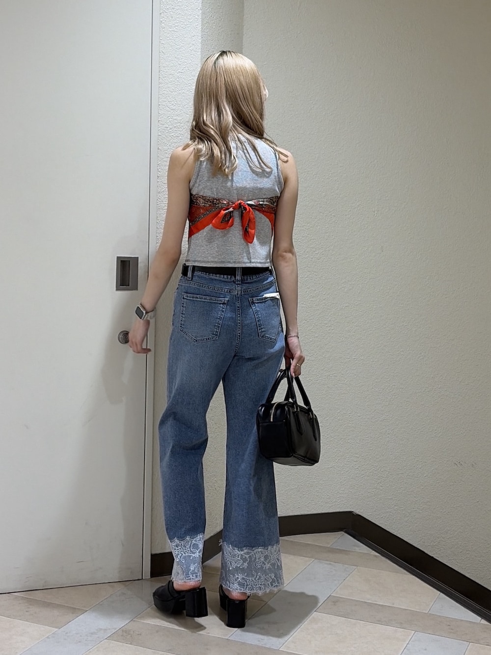 グレー系のTシャツ/カットソー、ブルー系のデニムパンツ、ブラック系のハンドバッグを着用したレディースの夏コーディネートの3枚目の写真