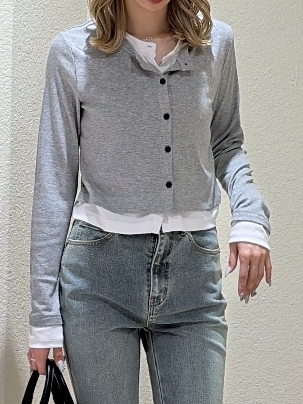 グレー系のTシャツ/カットソー、ブルー系のデニムパンツ、ブラック系のハンドバッグを着用したレディースの春コーディネートの6枚目の写真