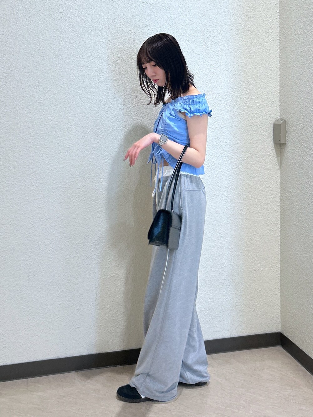 ブルー系のシャツ/ブラウス、ブラック系のショルダーバッグを着用したレディースの夏コーディネートの2枚目の写真