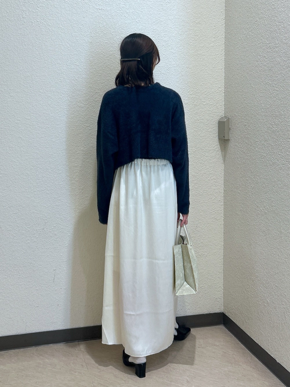 ブルー系のニット/セーター、ホワイト系のスカート、ホワイト系のトートバッグを着用したレディースの秋コーディネートの3枚目の写真