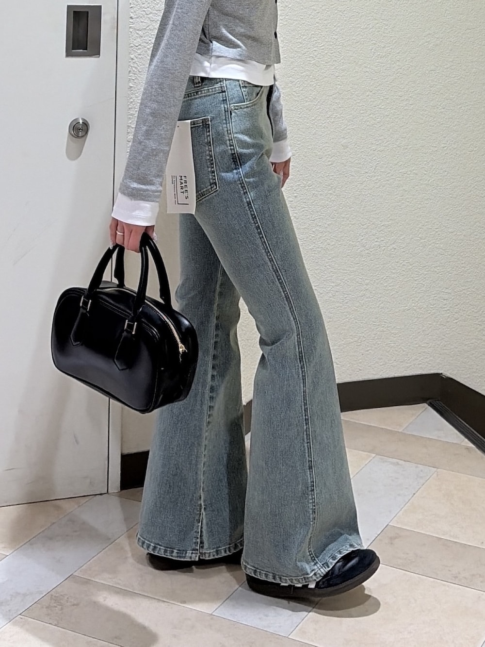 グレー系のTシャツ/カットソー、ブルー系のデニムパンツ、ブラック系のハンドバッグを着用したレディースの春コーディネートの5枚目の写真