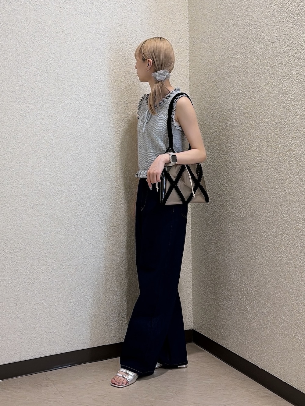 ブルー系のニット/セーター、ブルー系のデニムパンツ、ブラック系のトートバッグを着用したレディースの夏コーディネートの2枚目の写真