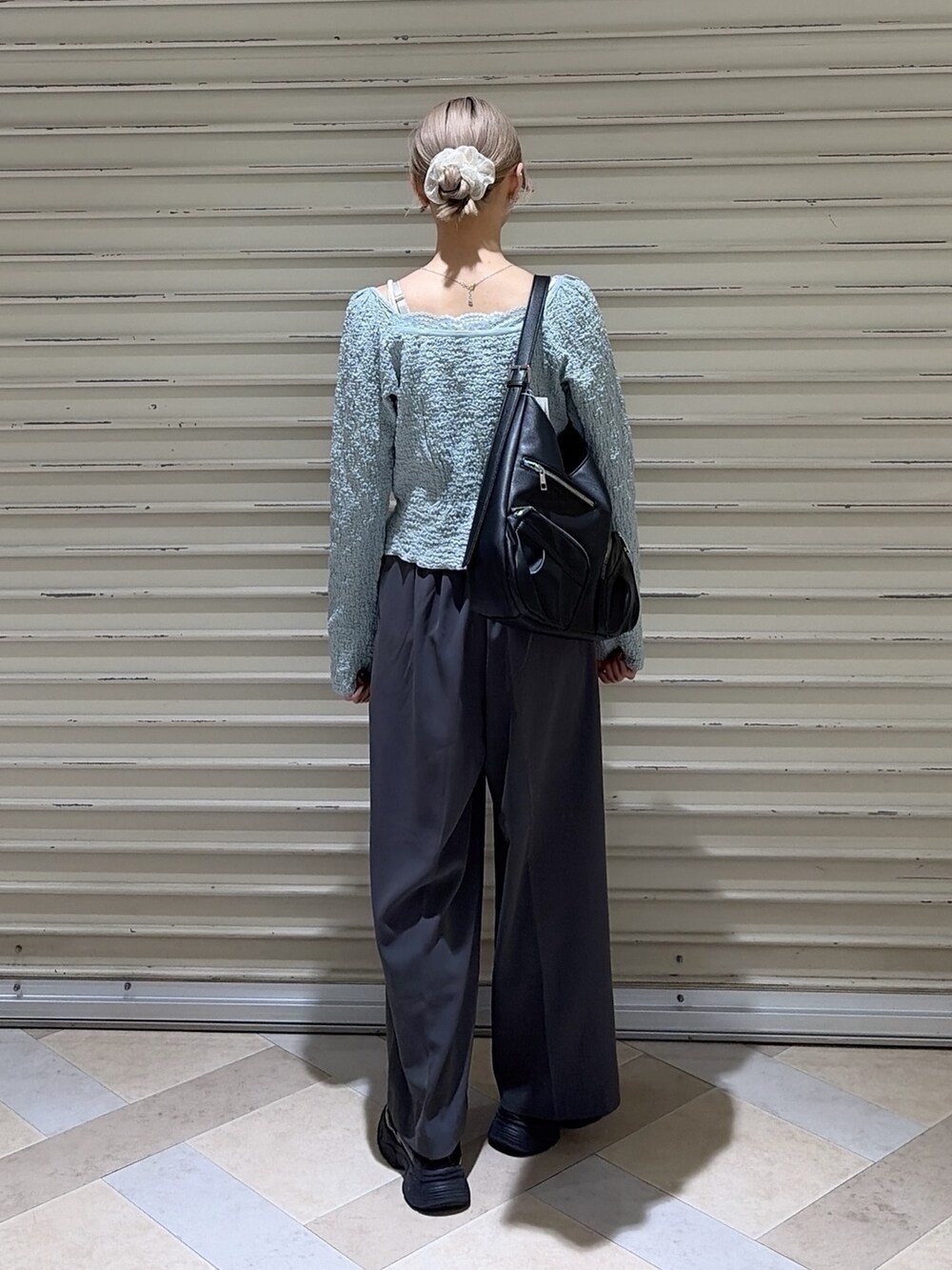 グレー系のスラックス、ブルー系のTシャツ/カットソー、ブラック系のトートバッグを着用したレディースの春コーディネートの5枚目の写真