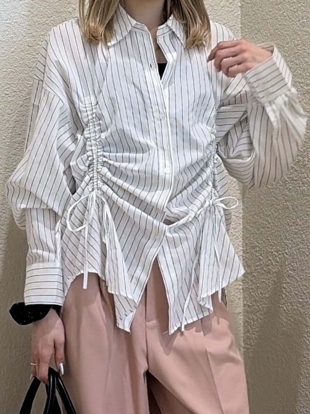 ホワイト系のシャツ/ブラウス、ピンク系のスラックス、ブラック系のハンドバッグを着用したレディースの春コーディネートの5枚目の写真