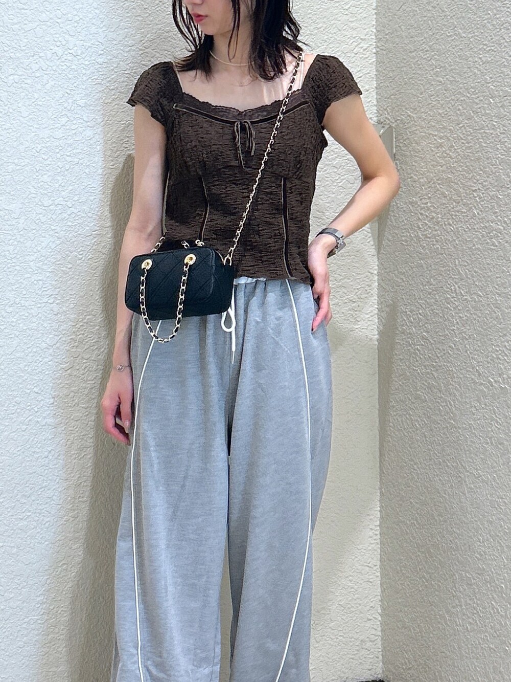 ブラウン系のTシャツ/カットソー、ブラック系のショルダーバッグを着用したレディースの夏コーディネートの4枚目の写真