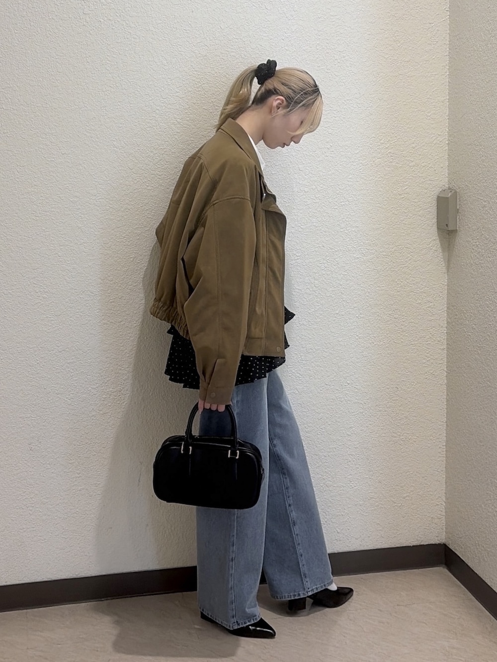 ブラック系のシャツ/ブラウス、ブラック系のハンドバッグ、ブルー系のその他パンツを着用したレディースの冬コーディネートの2枚目の写真