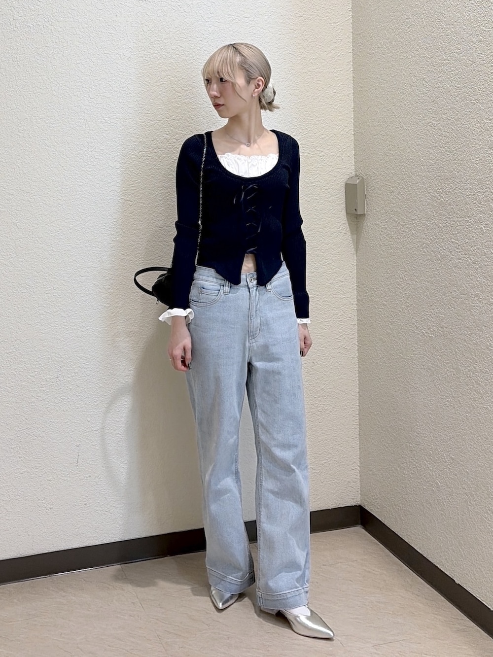 ブルー系のニット/セーター、ブルー系のデニムパンツ、シルバー系のパンプスを着用したレディースの春コーディネートの5枚目の写真