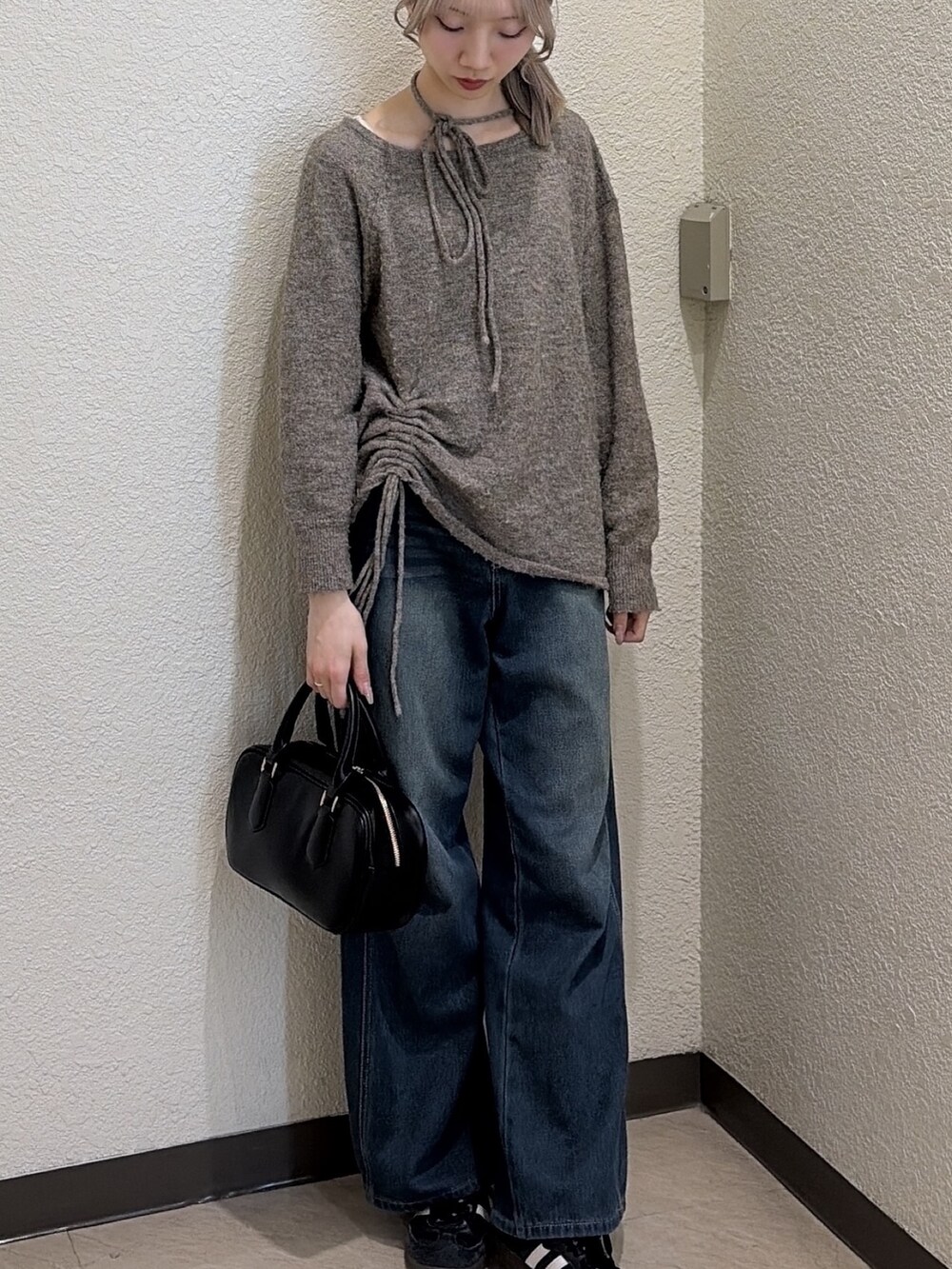 ブラウン系のニット/セーター、ブルー系のデニムパンツ、ブラック系のハンドバッグを着用したレディースの冬コーディネートの5枚目の写真