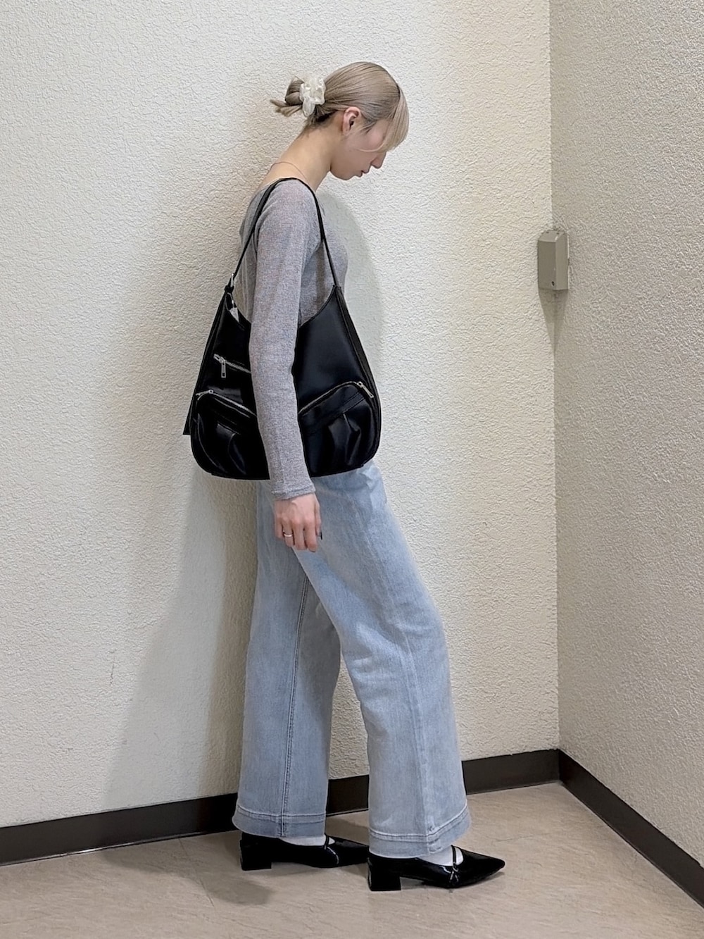 グレー系のTシャツ/カットソー、ブルー系のデニムパンツ、ブラック系のトートバッグを着用したレディースの春コーディネートの4枚目の写真