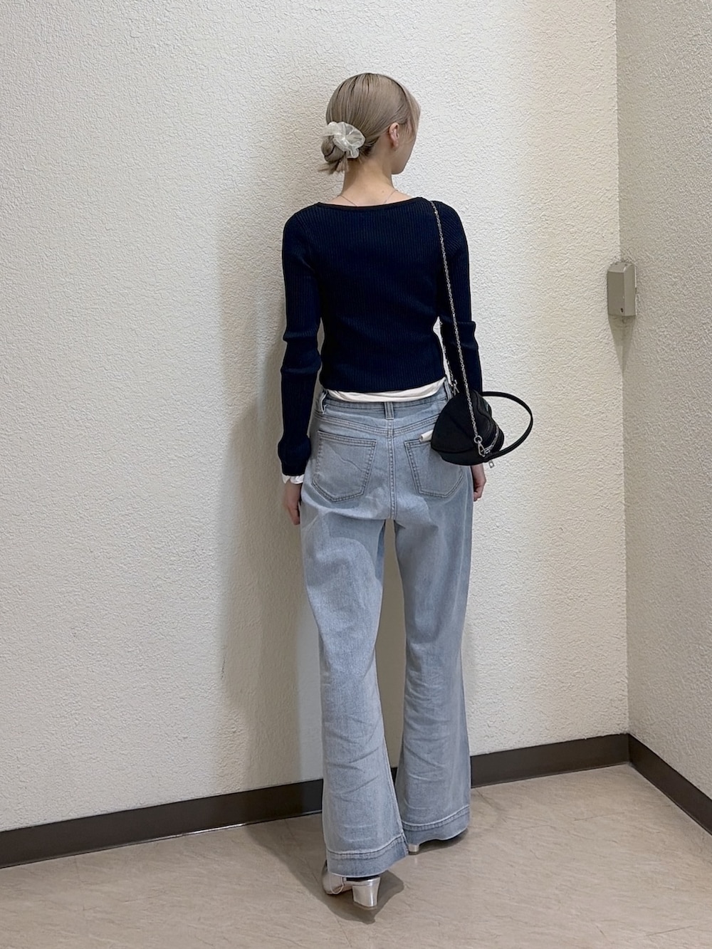 ブルー系のニット/セーター、ブルー系のデニムパンツ、シルバー系のパンプスを着用したレディースの春コーディネートの4枚目の写真