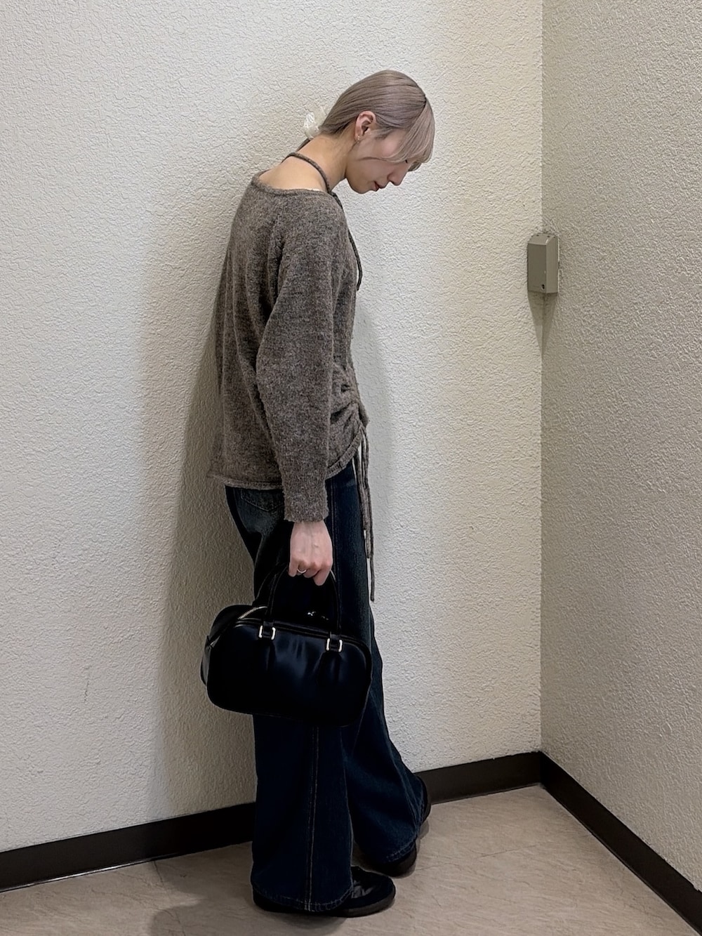 ブラウン系のニット/セーター、ブルー系のデニムパンツ、ブラック系のハンドバッグを着用したレディースの冬コーディネートの3枚目の写真