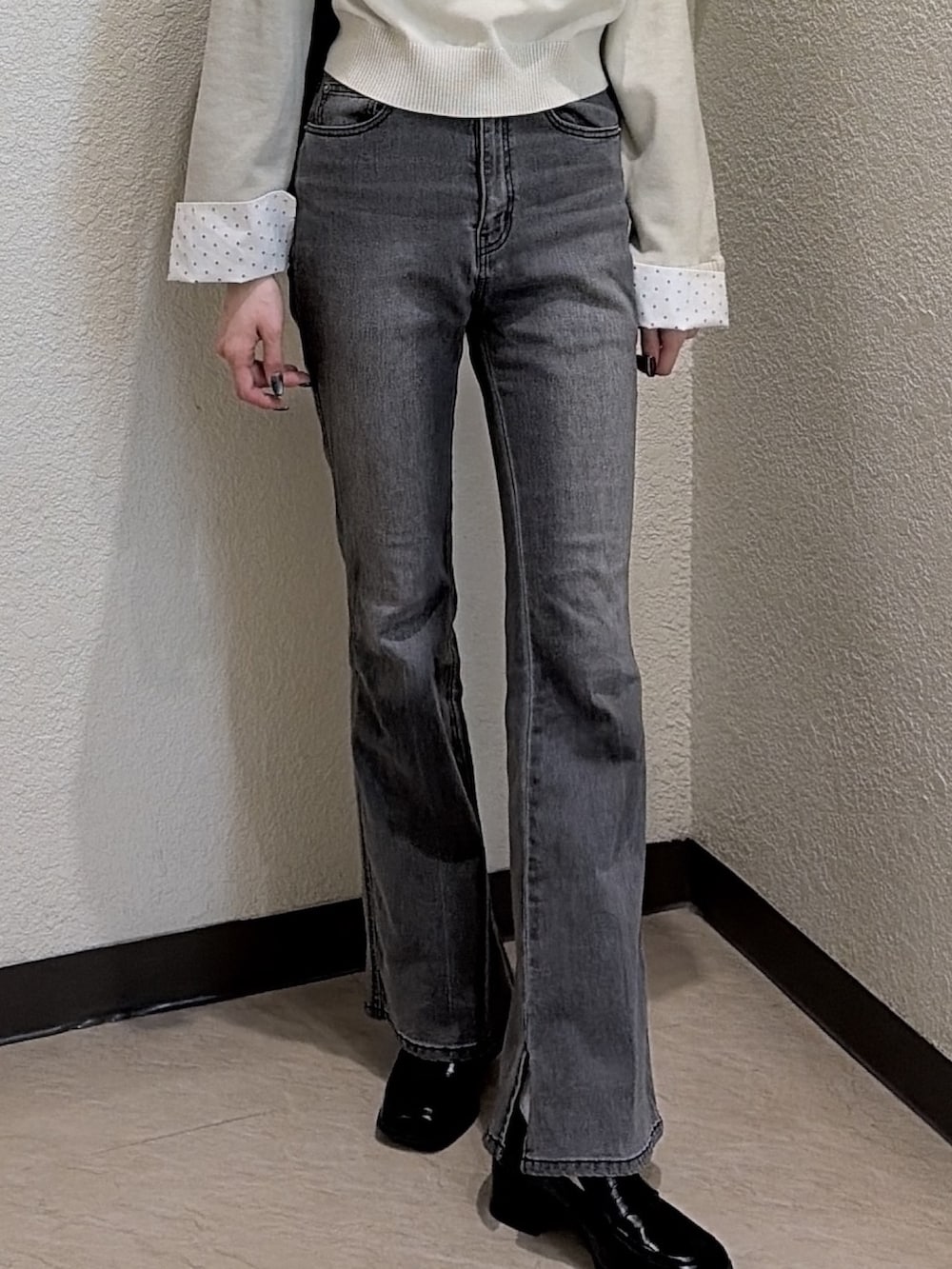 ブラック系のデニムパンツ、ブラック系のローファー、ベージュ系のニット/セーターを着用したレディースの春コーディネートの5枚目の写真