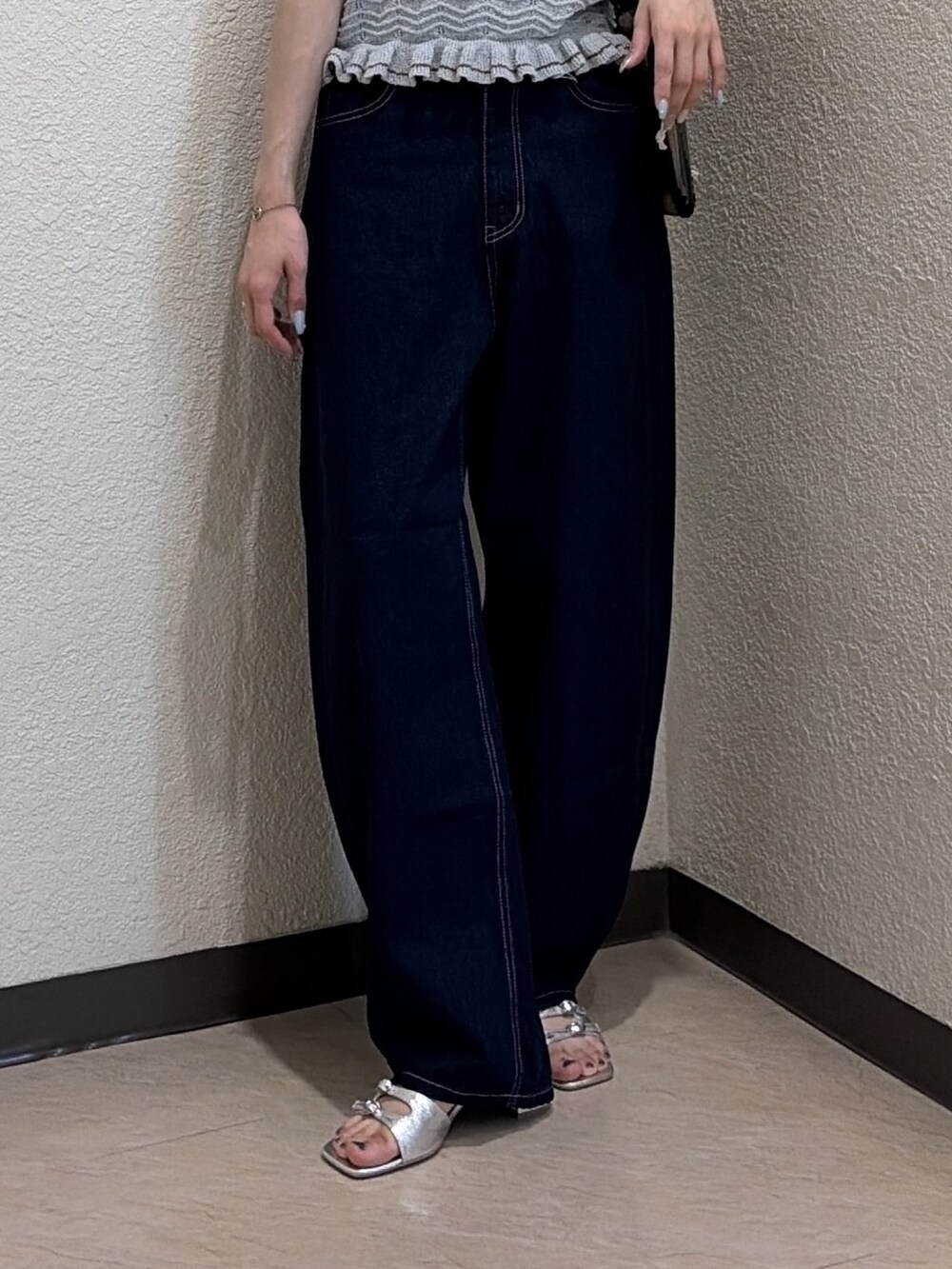 ブルー系のニット/セーター、ブルー系のデニムパンツ、ブラック系のトートバッグを着用したレディースの夏コーディネートの6枚目の写真