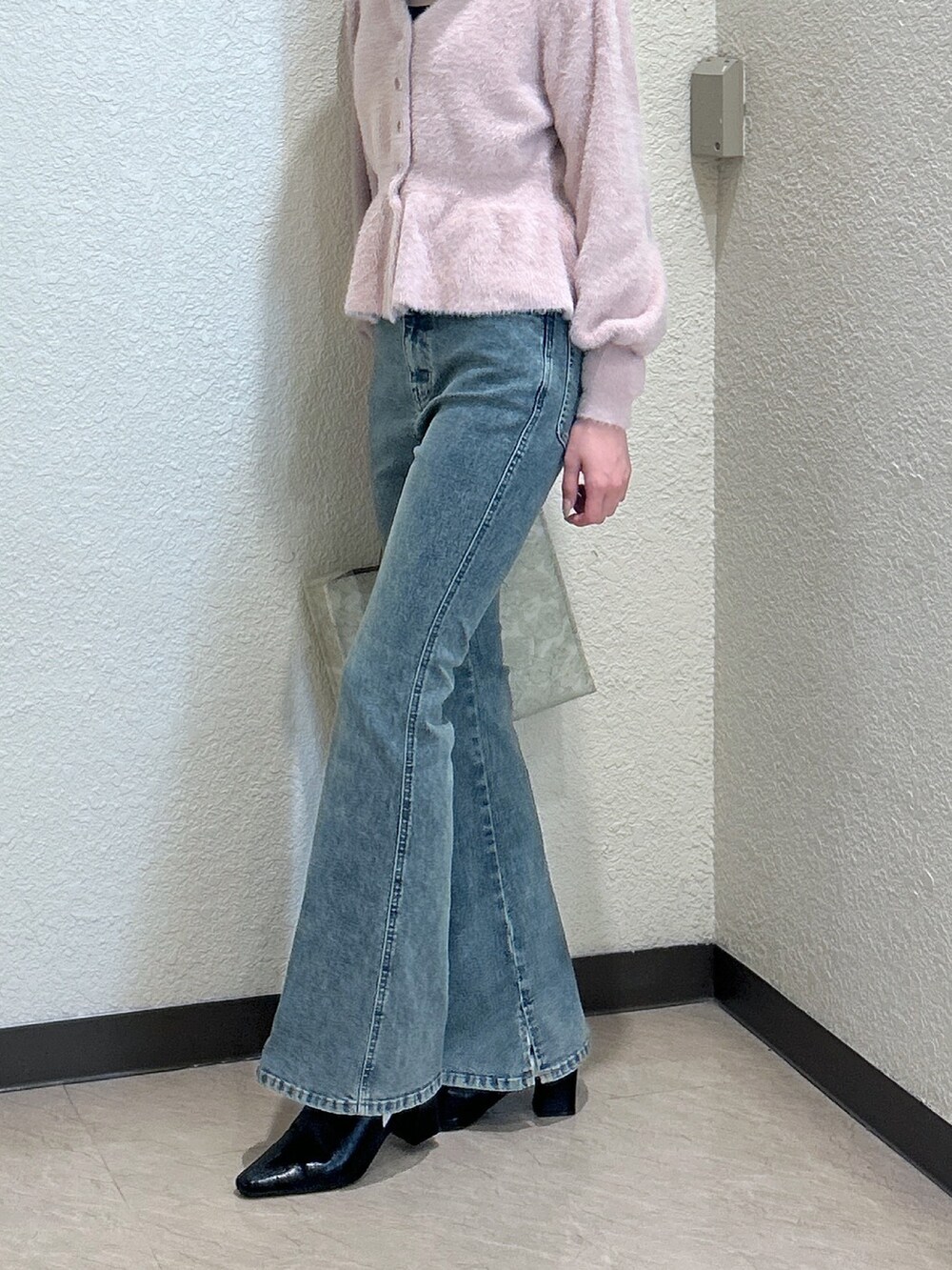 ピンク系のニット/セーター、ブルー系のデニムパンツ、ホワイト系のトートバッグを着用したレディースの秋コーディネートの3枚目の写真