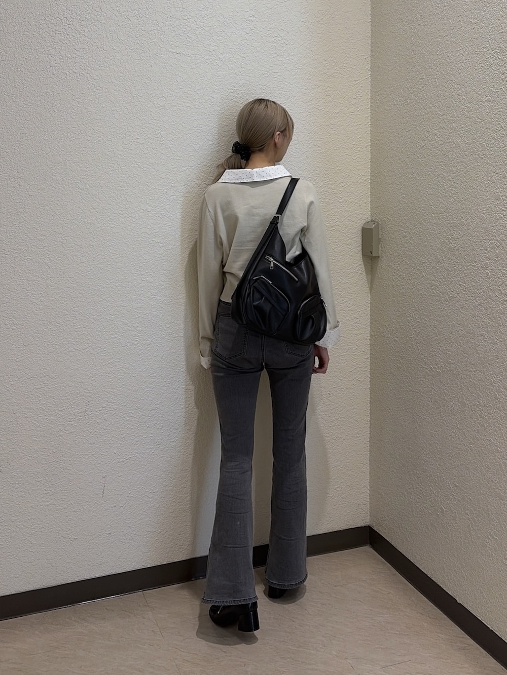 ブラック系のデニムパンツ、ブラック系のローファー、ベージュ系のニット/セーターを着用したレディースの春コーディネートの4枚目の写真