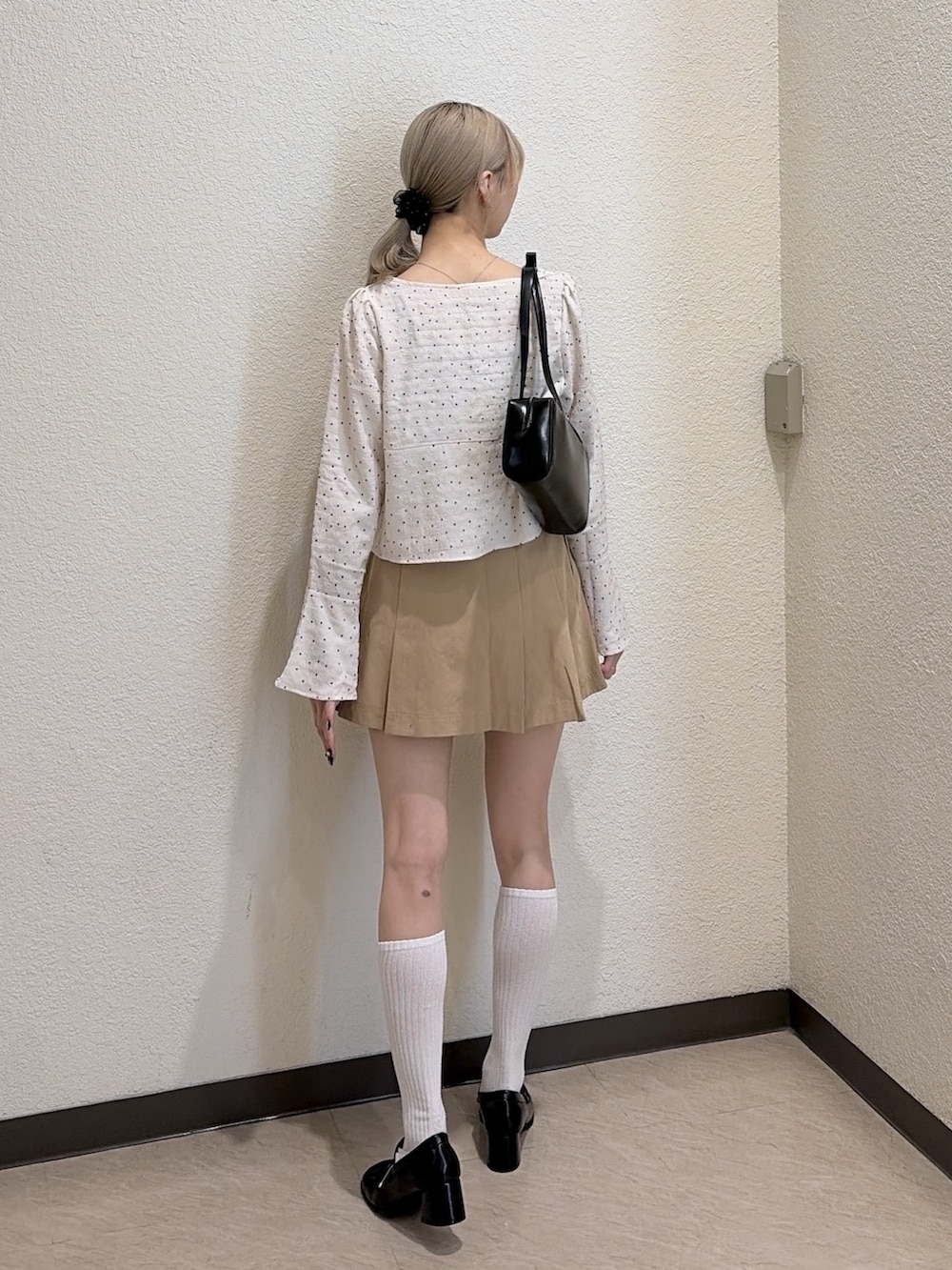 ベージュ系のスカート、ブラック系のローファー、ホワイト系のシャツ/ブラウスを着用したレディースの春コーディネートの3枚目の写真