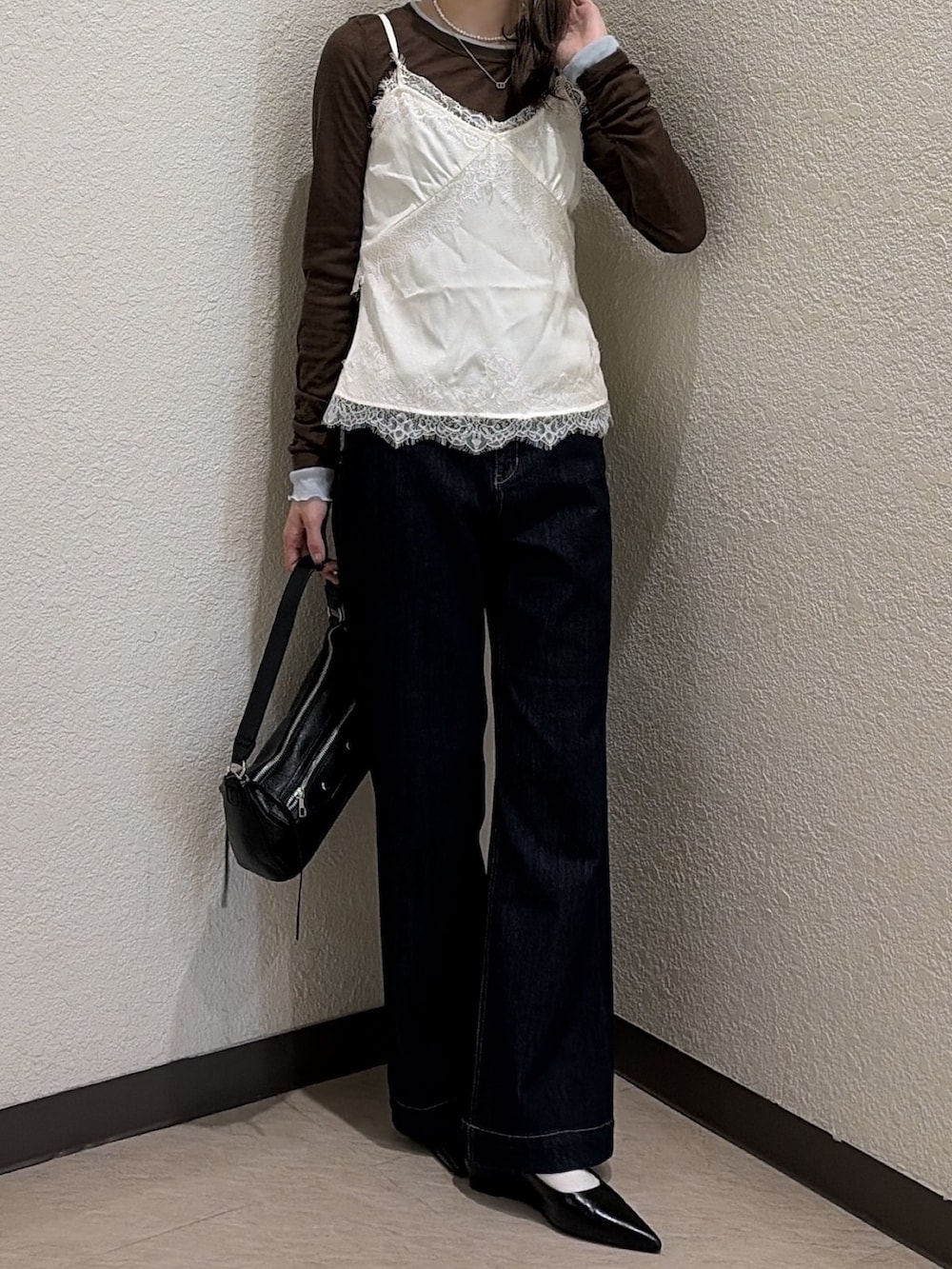 ブラウン系のTシャツ/カットソー、ブルー系のデニムパンツ、ホワイト系のシャツ/ブラウスを着用したレディースの秋コーディネートの4枚目の写真