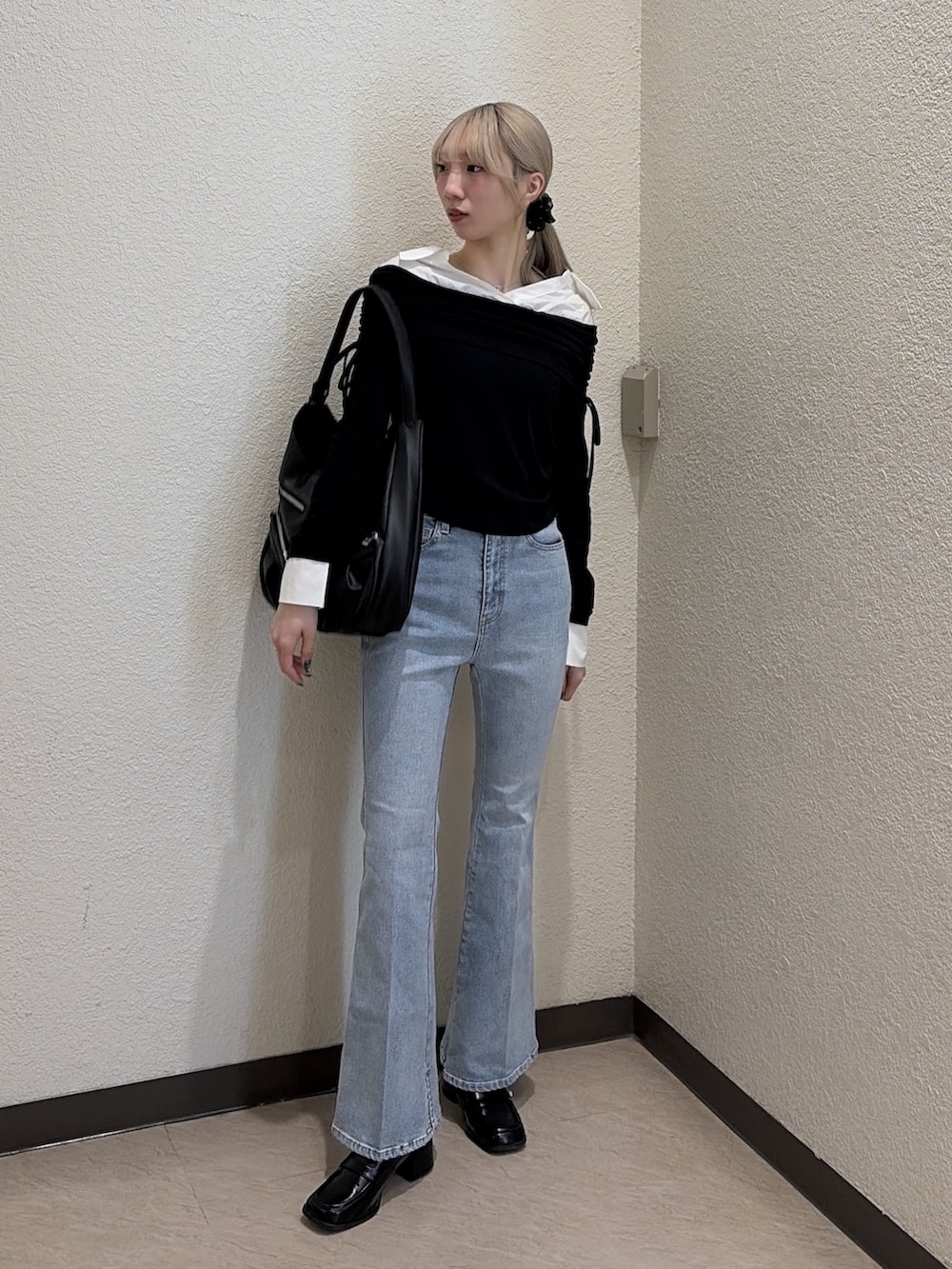 ブラック系のTシャツ/カットソー、ブルー系のデニムパンツ、ブラック系のトートバッグを着用したレディースの春コーディネートの5枚目の写真