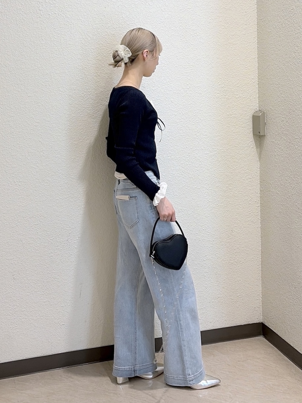 ブルー系のニット/セーター、ブルー系のデニムパンツ、シルバー系のパンプスを着用したレディースの春コーディネートの3枚目の写真