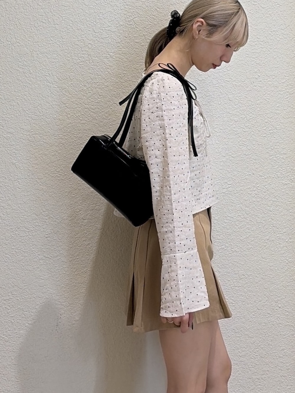 ベージュ系のスカート、ブラック系のローファー、ホワイト系のシャツ/ブラウスを着用したレディースの春コーディネートの4枚目の写真