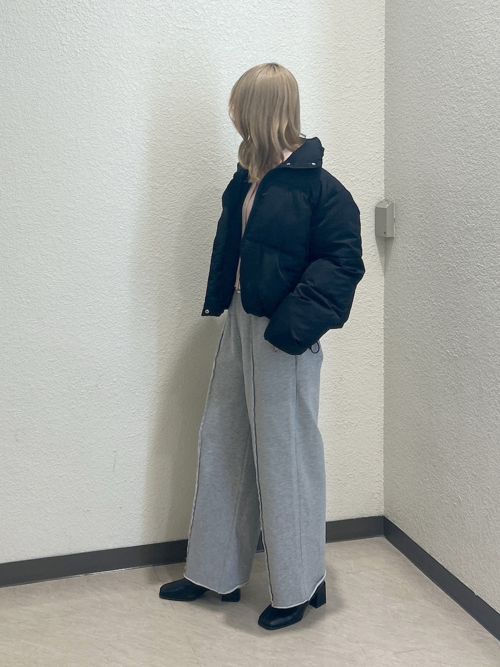 ブラック系のブルゾン、ピンク系のニット/セーター、グレー系のスウェットパンツを着用したレディースの冬コーディネートの2枚目の写真