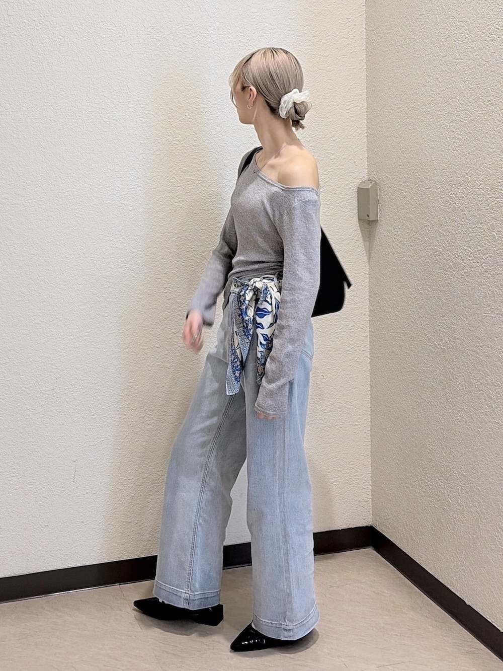 グレー系のTシャツ/カットソー、ブルー系のデニムパンツ、ブラック系のトートバッグを着用したレディースの春コーディネートの2枚目の写真