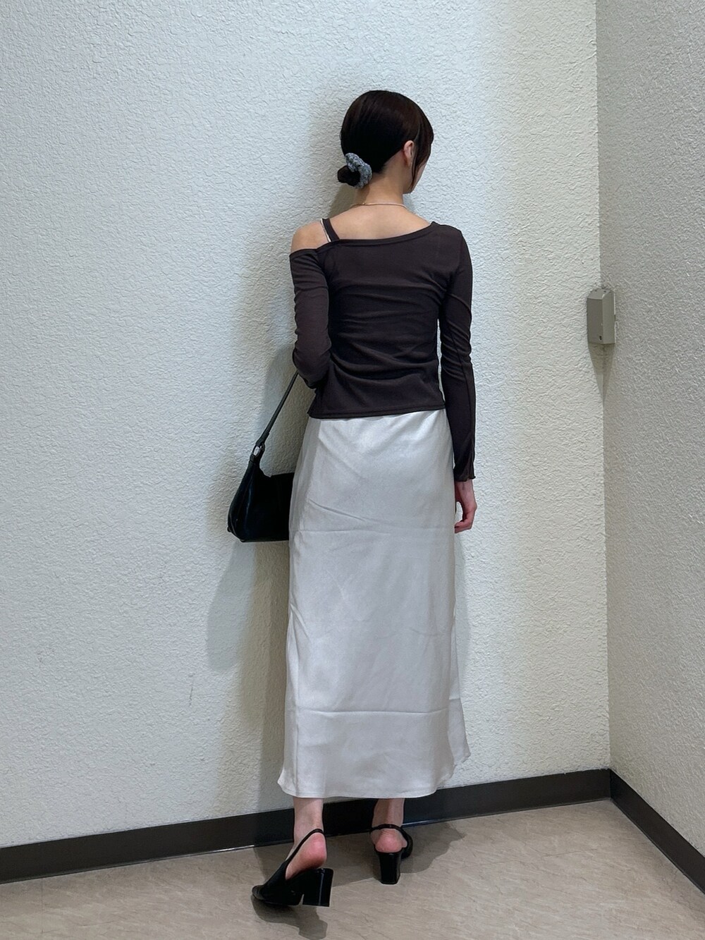 ブラウン系のTシャツ/カットソー、ホワイト系のスカート、ブラック系のパンプスを着用したレディースの秋コーディネートの3枚目の写真