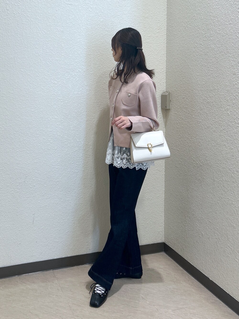 ベージュ系のニット/セーター、ブルー系のデニムパンツ、ホワイト系のトートバッグを着用したレディースの秋コーディネートの2枚目の写真