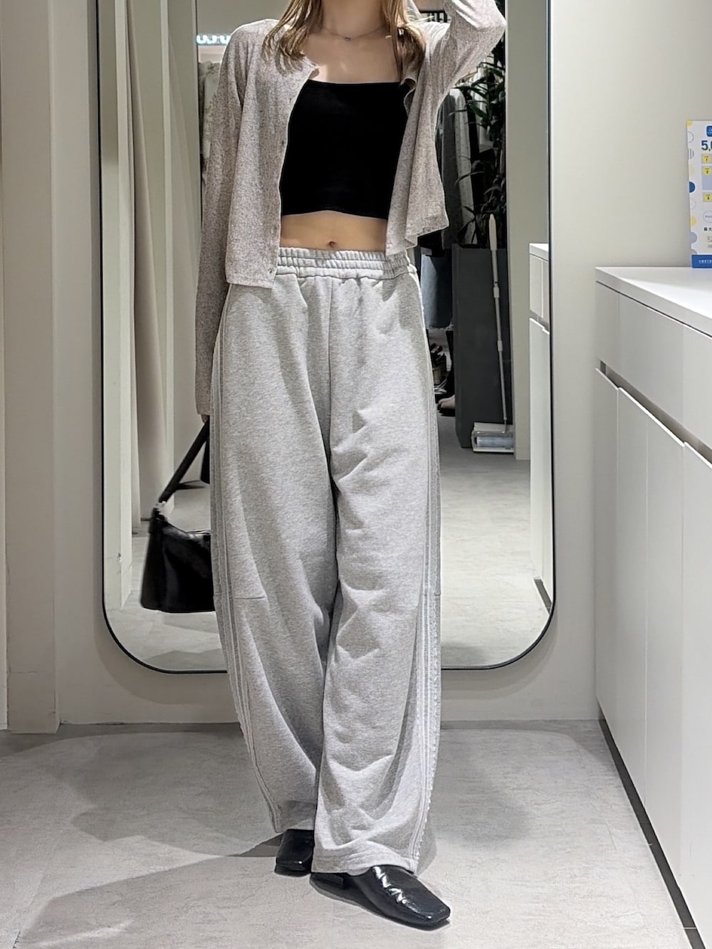 グレー系のTシャツ/カットソー、グレー系のスウェットパンツ、ブラック系のショルダーバッグを着用したレディースの秋コーディネートの4枚目の写真