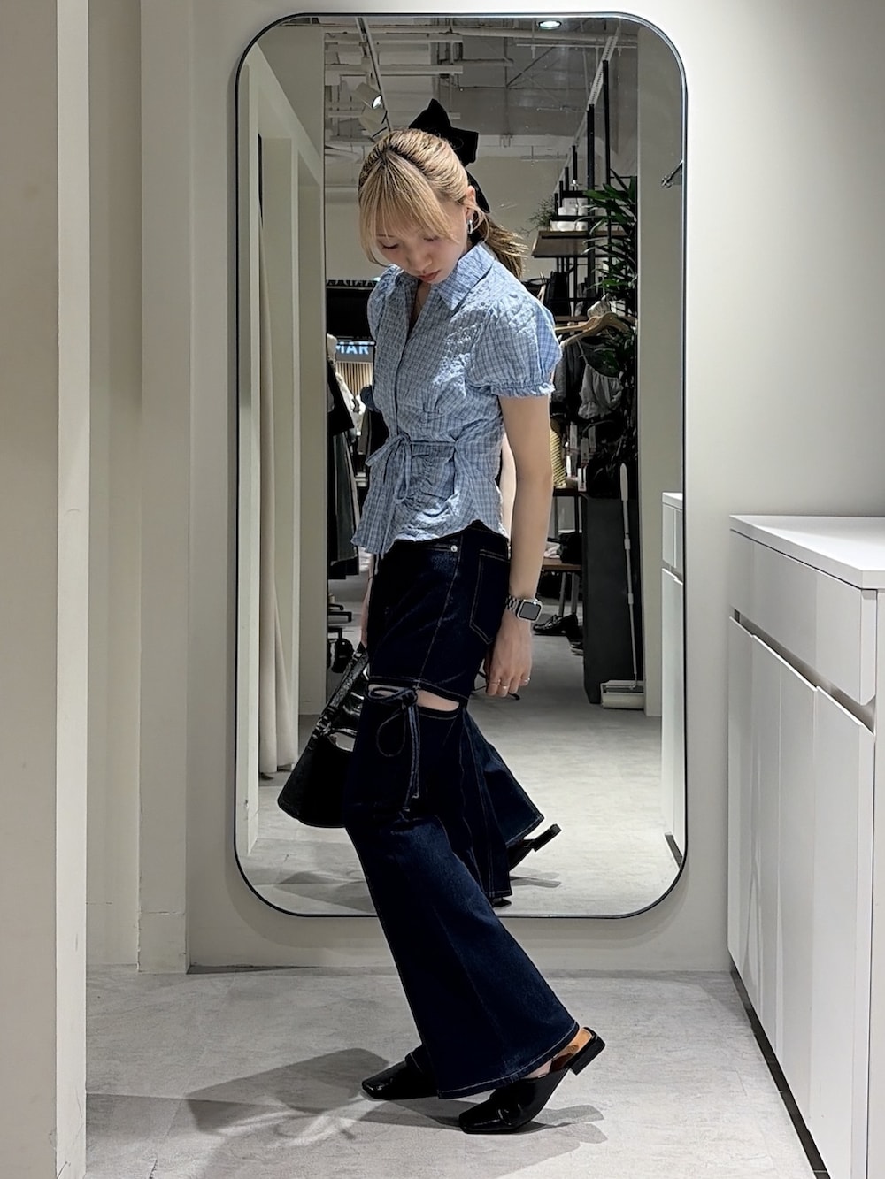 ブルー系のシャツ/ブラウス、ブルー系のデニムパンツ、ブラック系のショルダーバッグを着用したレディースの夏コーディネートの2枚目の写真