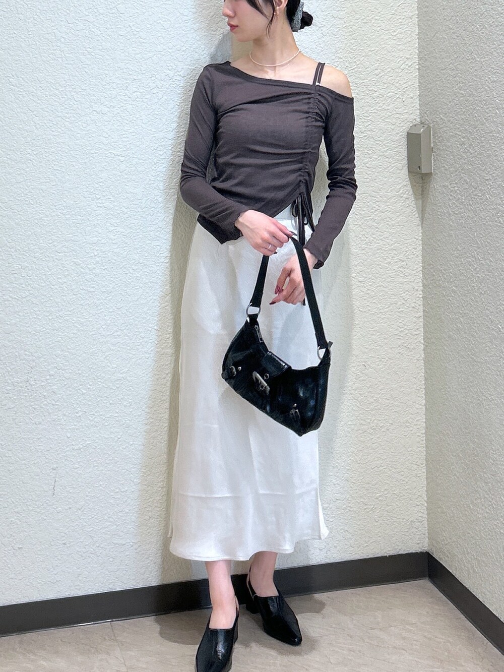 ブラウン系のTシャツ/カットソー、ホワイト系のスカート、ブラック系のパンプスを着用したレディースの秋コーディネートの4枚目の写真