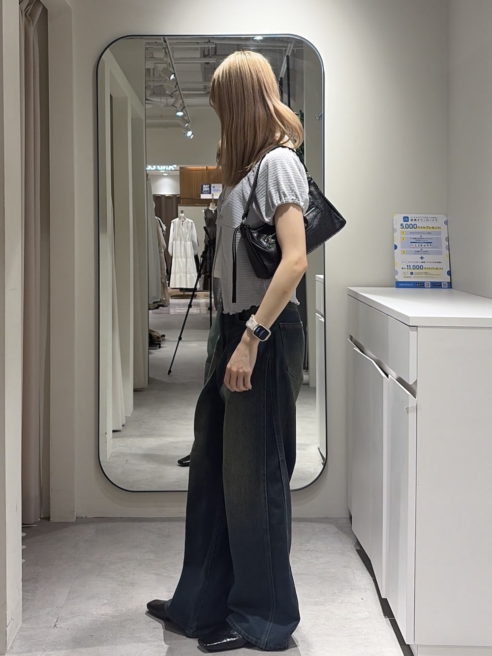 ブルー系のデニムパンツ、ブラック系のパンプス、ブルー系のTシャツ/カットソーを着用したレディースの夏コーディネートの2枚目の写真