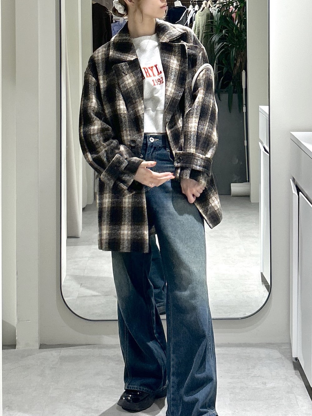 ホワイト系のスウェット、ブルー系のデニムパンツ、ブラウン系のピーコートを着用したレディースの秋コーディネートの5枚目の写真