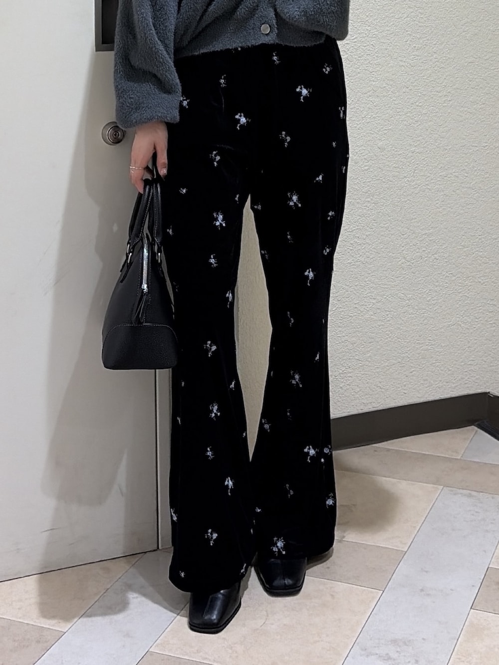 グレー系のニット/セーター、ブラック系のその他パンツ、ブラック系のブーツを着用したレディースの秋コーディネートの6枚目の写真