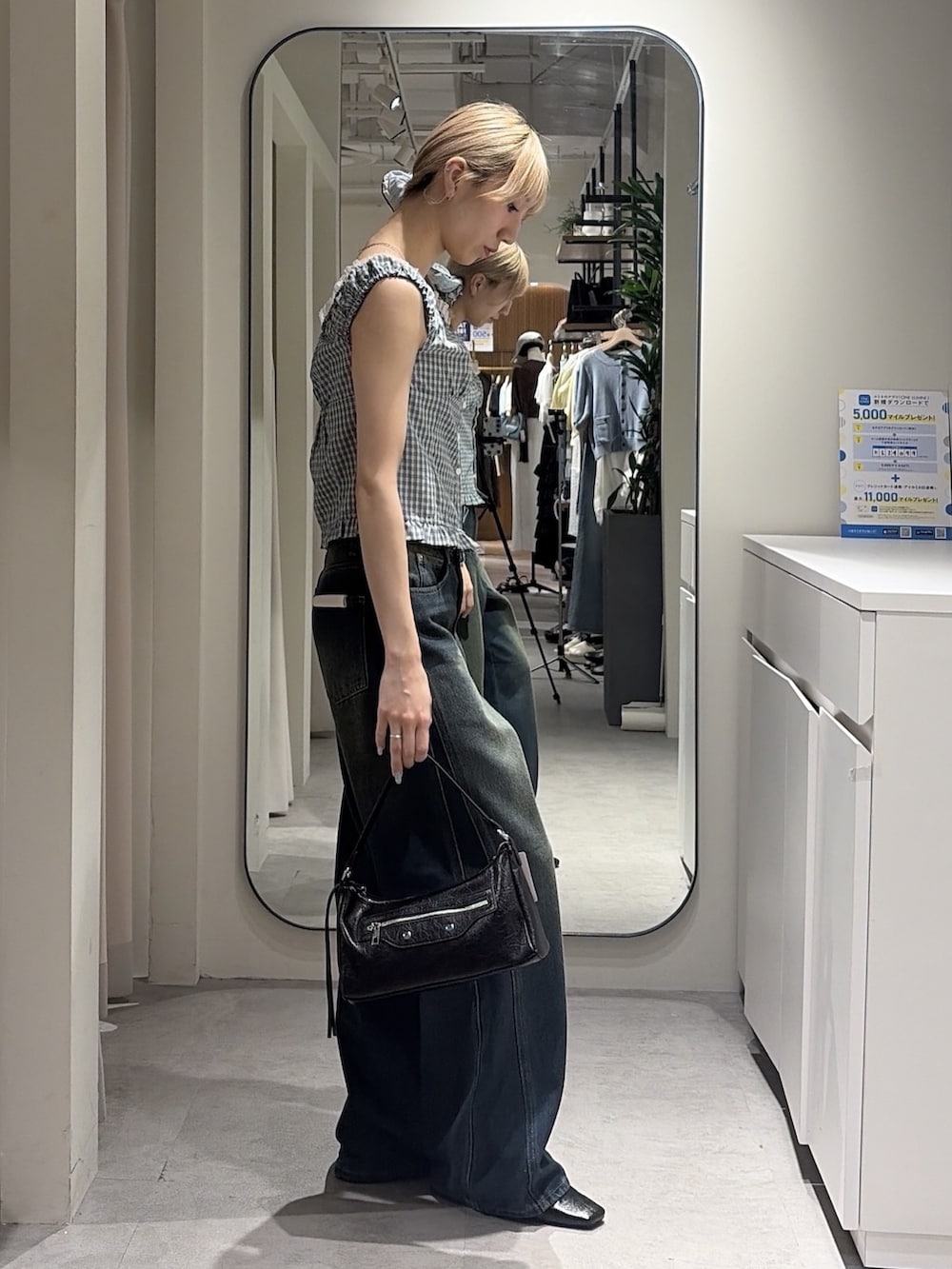ブルー系のシャツ/ブラウス、ブルー系のデニムパンツ、ブラック系のショルダーバッグを着用したレディースの夏コーディネートの2枚目の写真