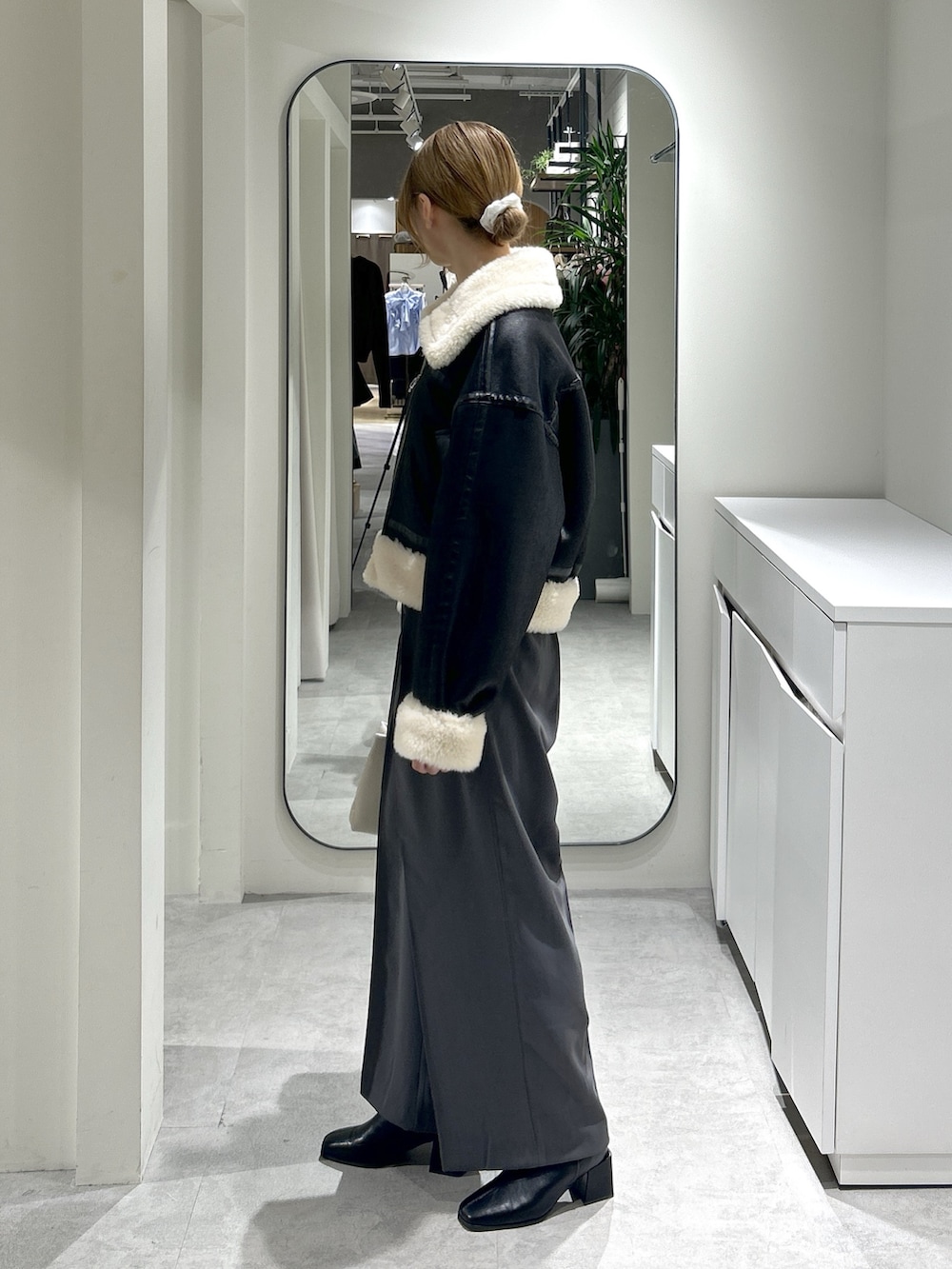 ブラック系のブルゾン、ブラック系のブーツ、グレー系のスラックスを着用したレディースの秋コーディネートの3枚目の写真