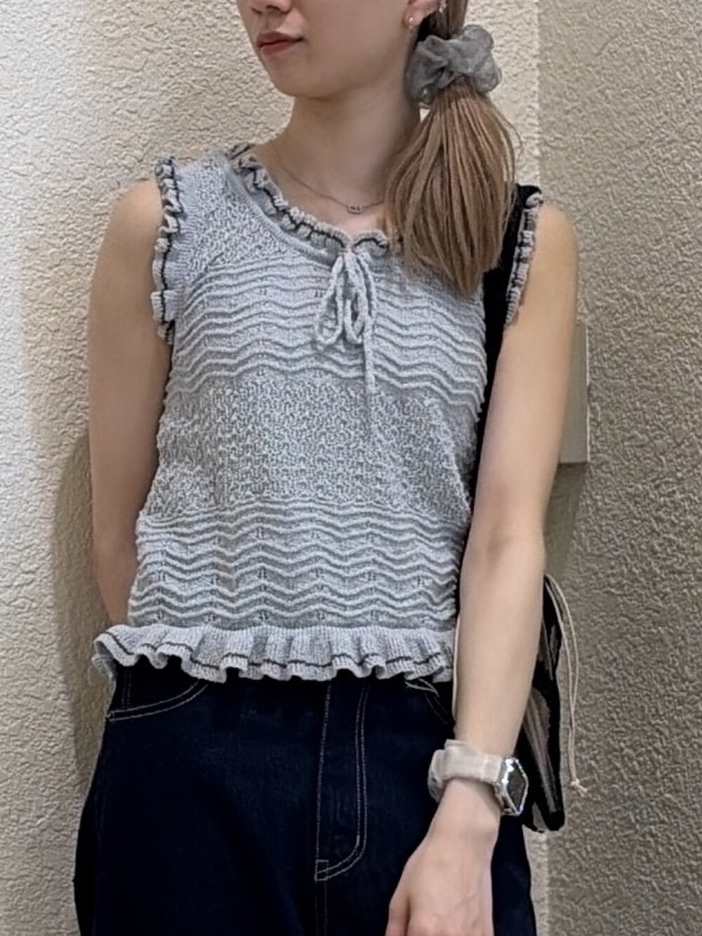 ブルー系のニット/セーター、ブルー系のデニムパンツ、ブラック系のトートバッグを着用したレディースの夏コーディネートの5枚目の写真