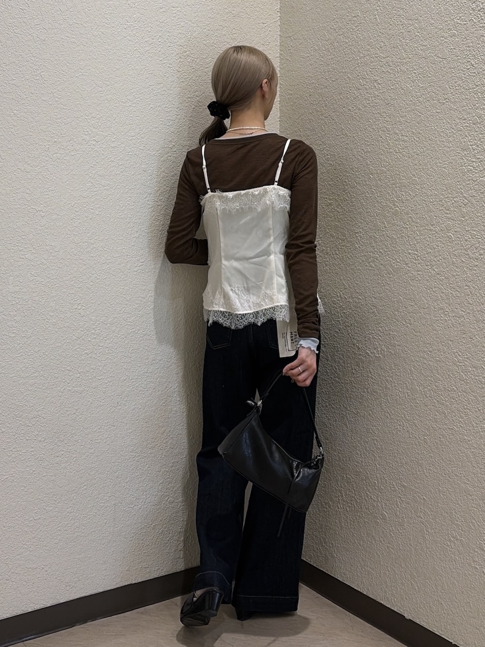 ブラウン系のTシャツ/カットソー、ブルー系のデニムパンツ、ホワイト系のシャツ/ブラウスを着用したレディースの秋コーディネートの3枚目の写真