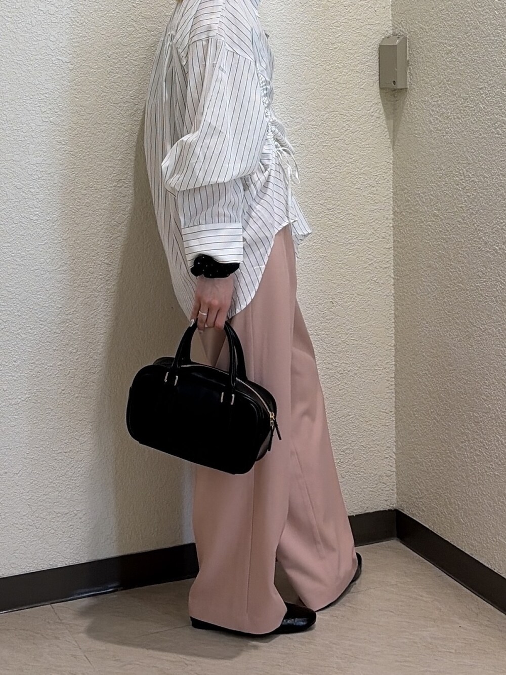 ホワイト系のシャツ/ブラウス、ピンク系のスラックス、ブラック系のハンドバッグを着用したレディースの春コーディネートの2枚目の写真
