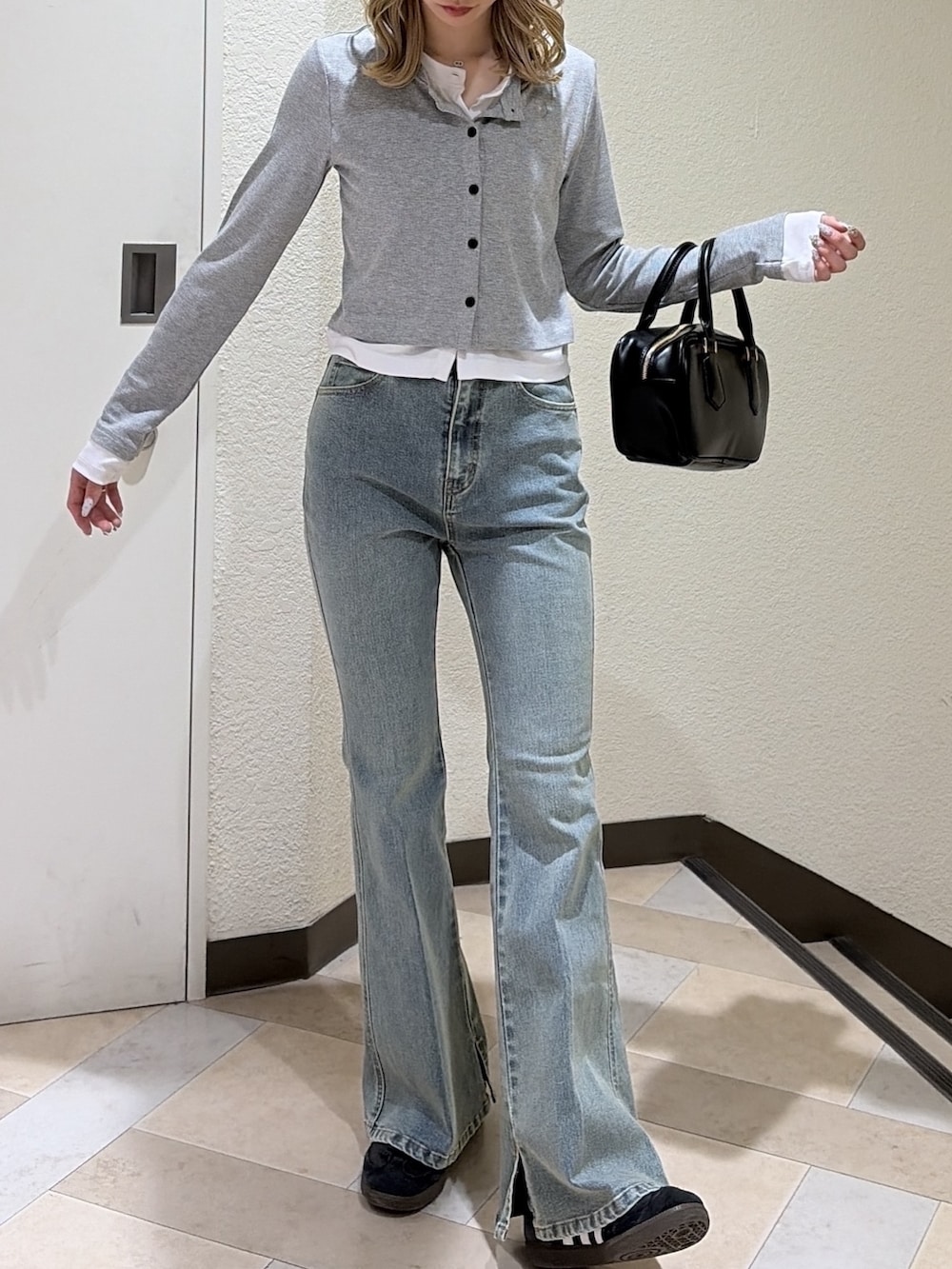 グレー系のTシャツ/カットソー、ブルー系のデニムパンツ、ブラック系のハンドバッグを着用したレディースの春コーディネートの4枚目の写真