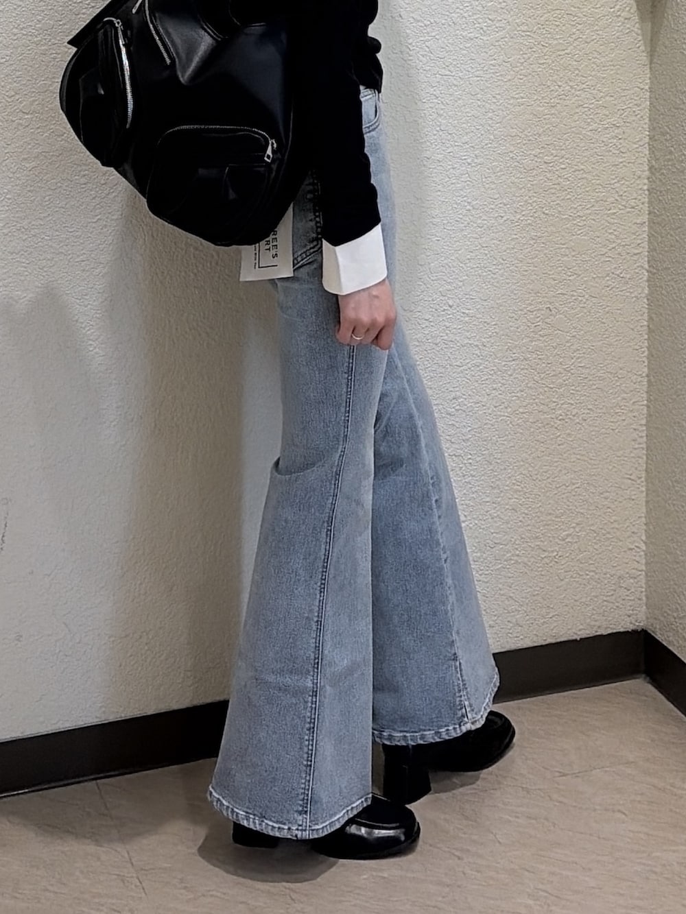 ブラック系のTシャツ/カットソー、ブルー系のデニムパンツ、ブラック系のトートバッグを着用したレディースの春コーディネートの4枚目の写真