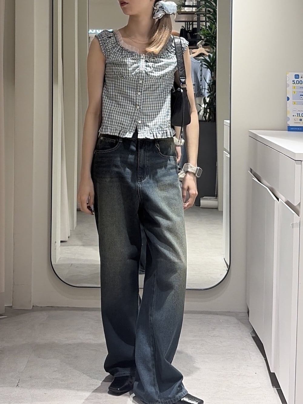 ブルー系のシャツ/ブラウス、ブルー系のデニムパンツ、ブラック系のショルダーバッグを着用したレディースの夏コーディネートの4枚目の写真