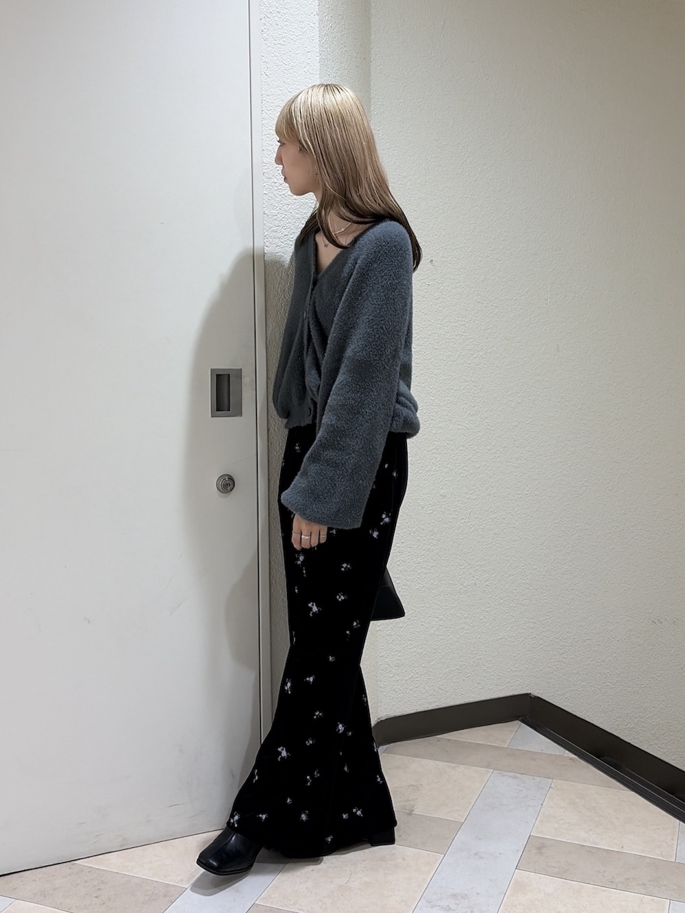 グレー系のニット/セーター、ブラック系のその他パンツ、ブラック系のブーツを着用したレディースの秋コーディネートの2枚目の写真
