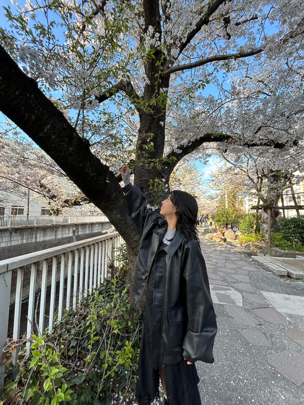 ブラック系のワンピース、ブラック系のブーツ、ブラック系のジャケット/アウターを着用したレディースの春コーディネートの3枚目の写真