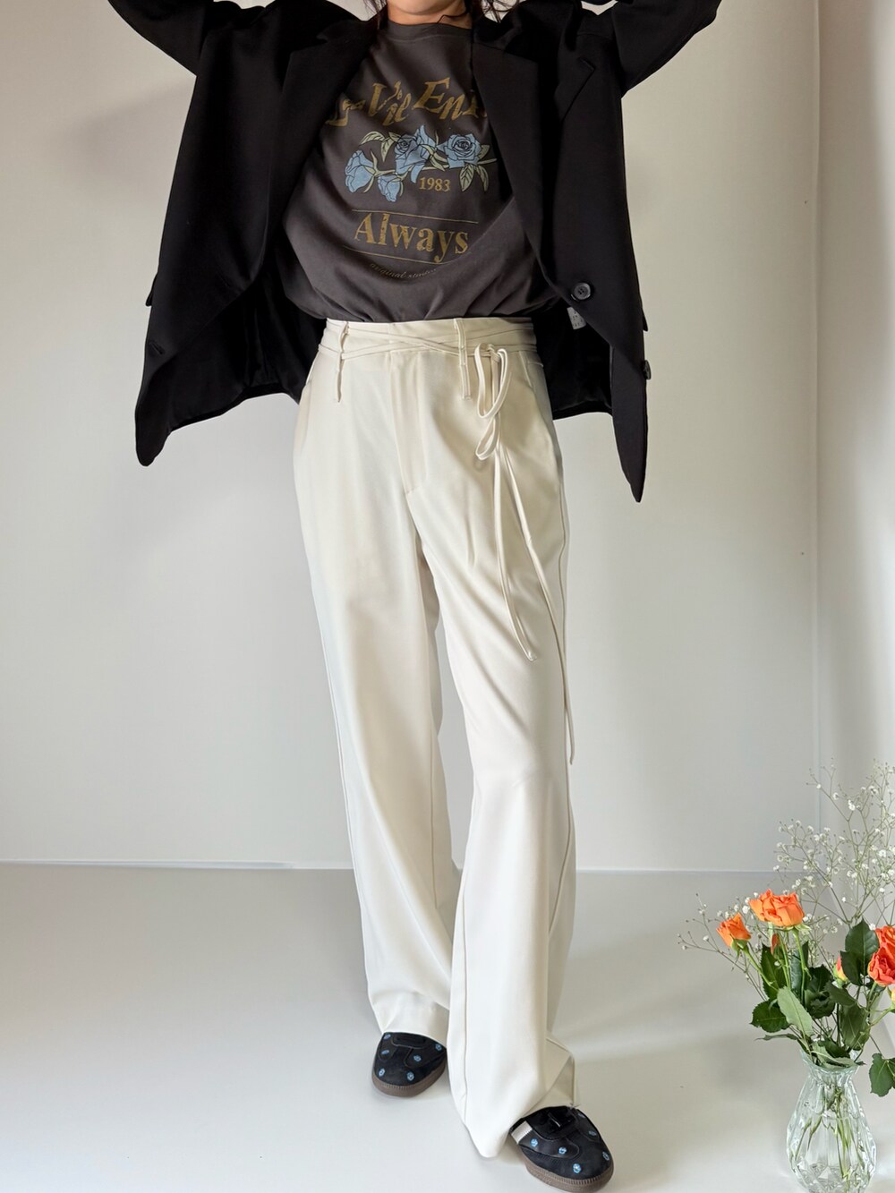 グレー系のTシャツ/カットソー、ホワイト系のスラックス、ブラック系のスニーカーを着用したレディースの春コーディネートの3枚目の写真