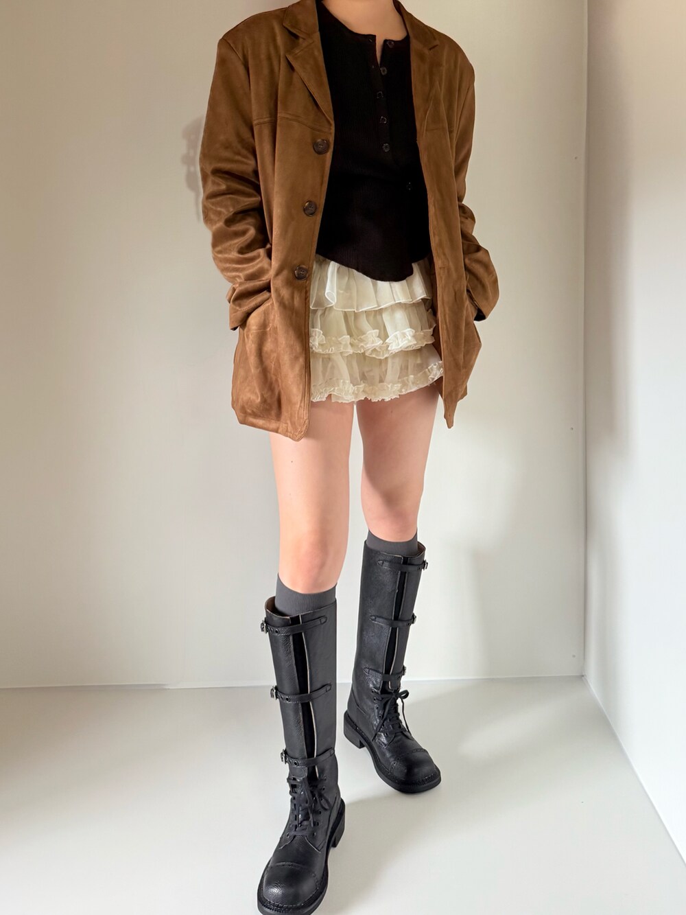 ブラック系のカーディガン/ボレロ、ブラウン系のテーラードジャケット、ホワイト系のスカートを着用したレディースの春コーディネートの4枚目の写真