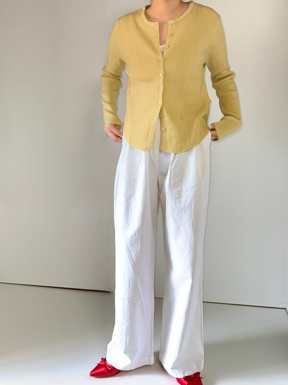 ピンク系のカーディガン/ボレロ、レッド系のパンプスを着用したレディースの春コーディネートの2枚目の写真