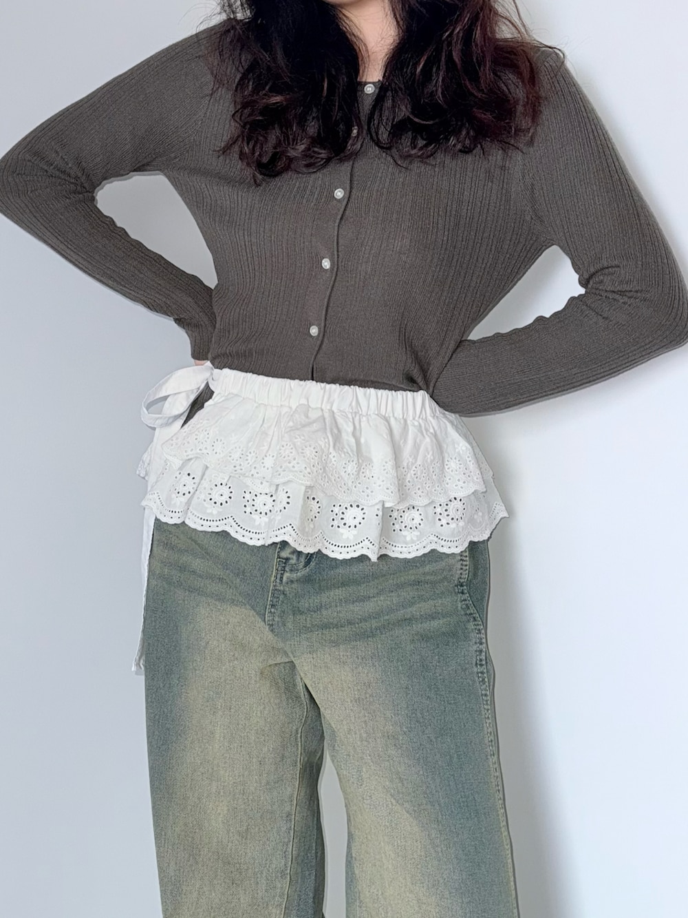 ブラウン系のカーディガン/ボレロ、ホワイト系のスカート、ブルー系のデニムパンツを着用したレディースの春コーディネートの4枚目の写真