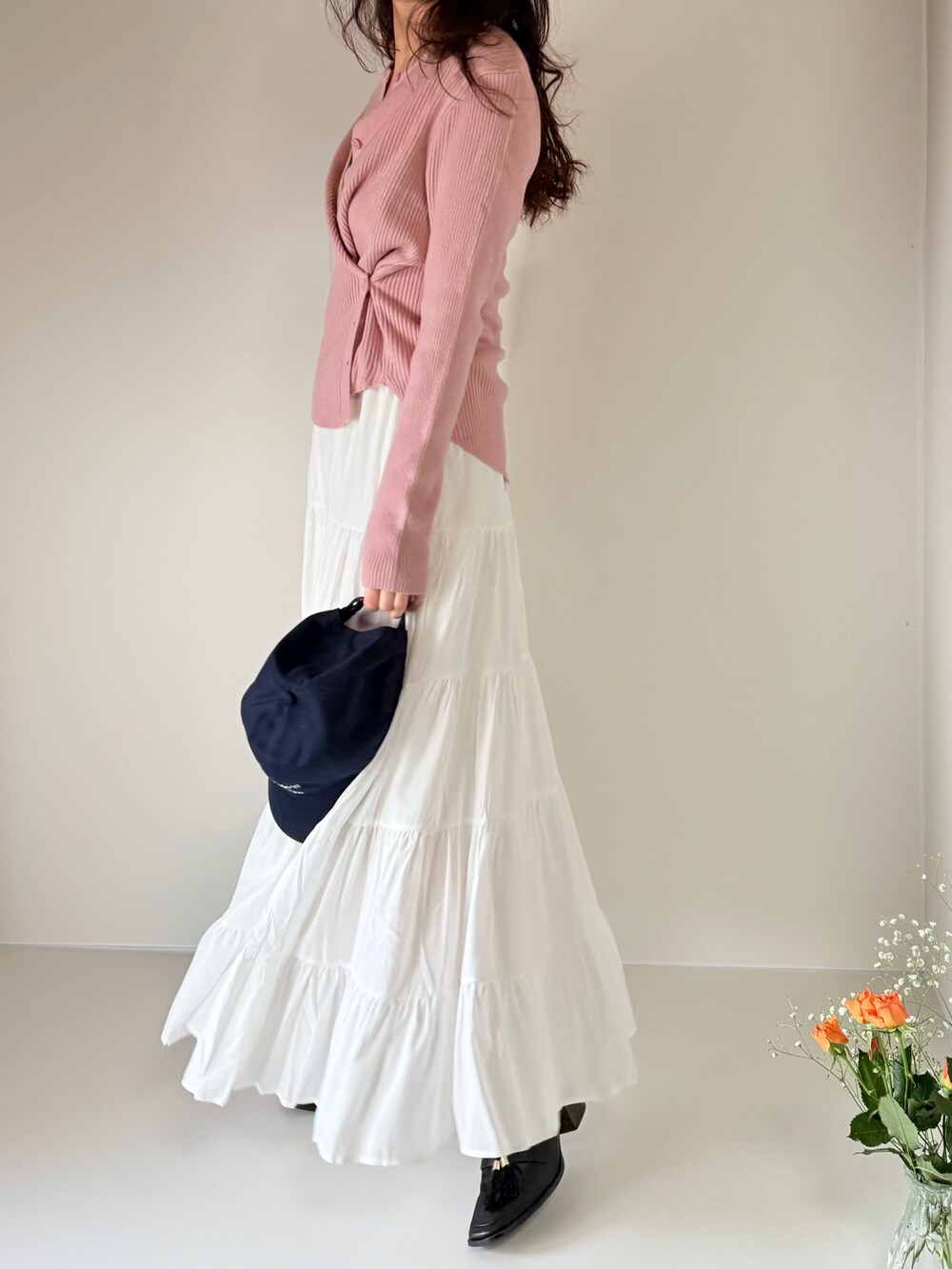 ホワイト系のスカート、ピンク系のカーディガン/ボレロ、ブラウン系のベルトを着用したレディースの春コーディネートの4枚目の写真