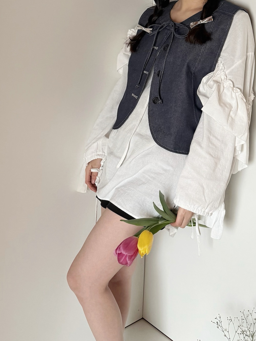 ブルー系のベストを着用したレディースの春コーディネートの4枚目の写真